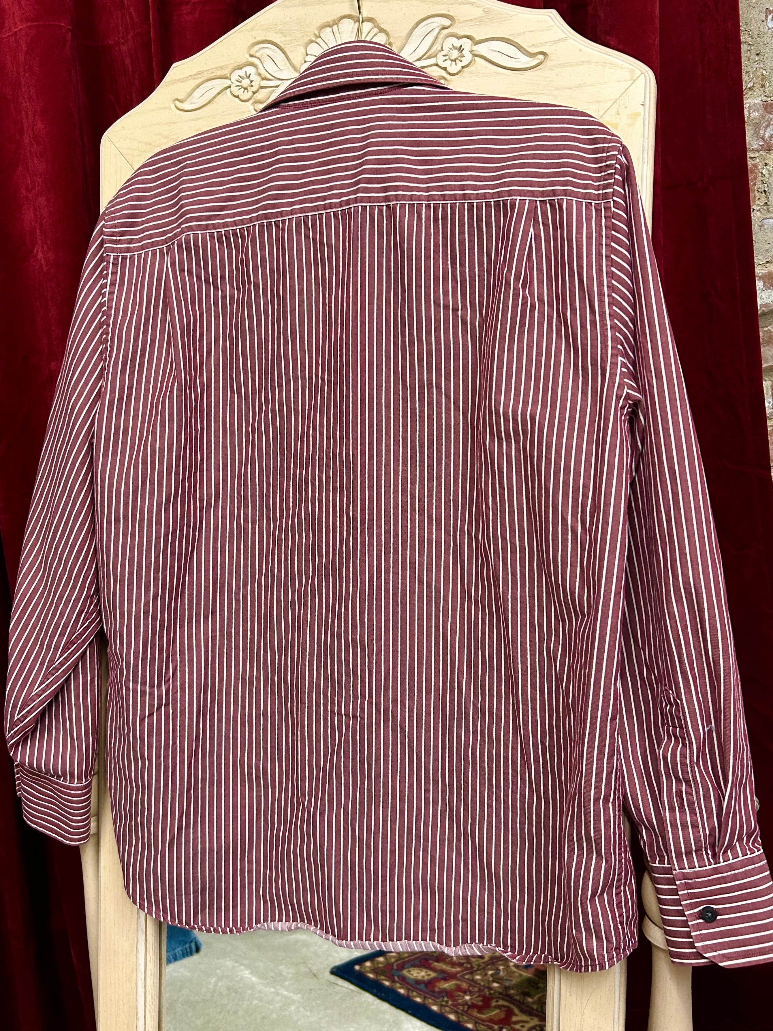 Striped shirt on a decorative chair with a red curtain background