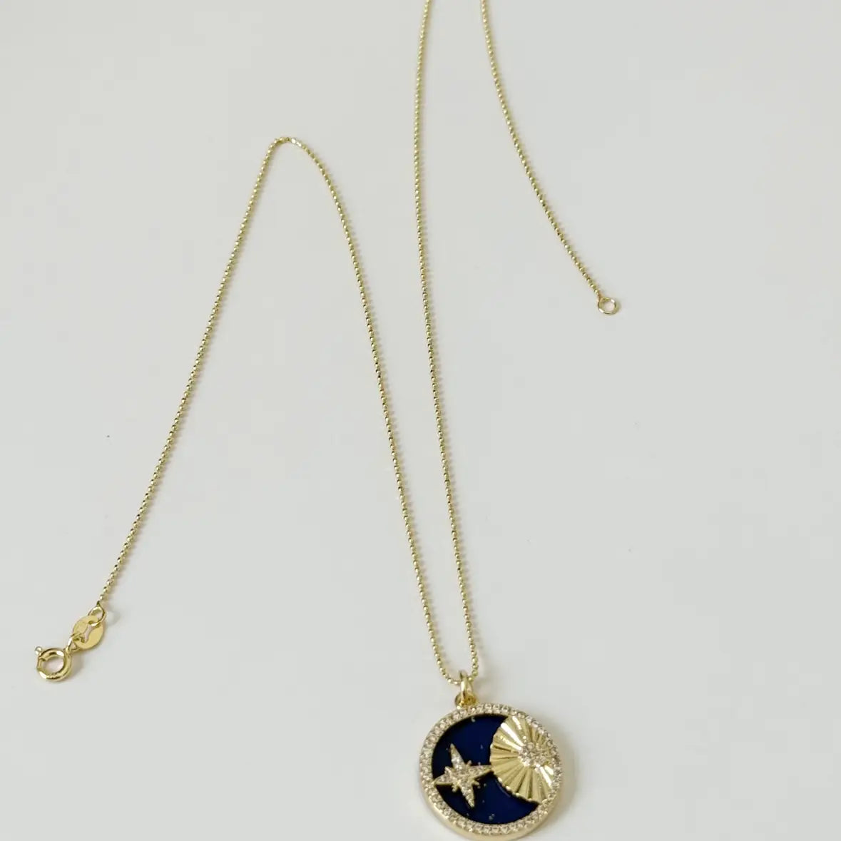 Necklace with a blue pendant featuring a star design on a light gray background