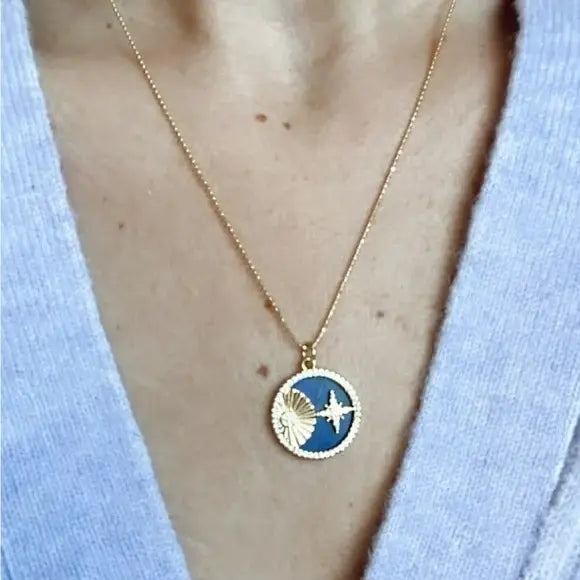 Necklace with a blue pendant featuring a white airplane design, worn by a person against a light blue background.