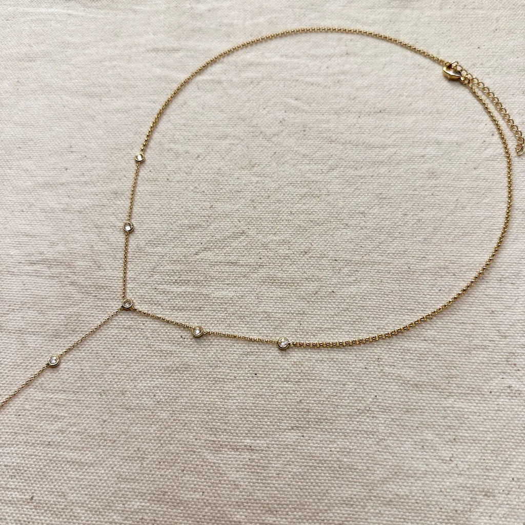 Gold necklace with small beads on a beige fabric background