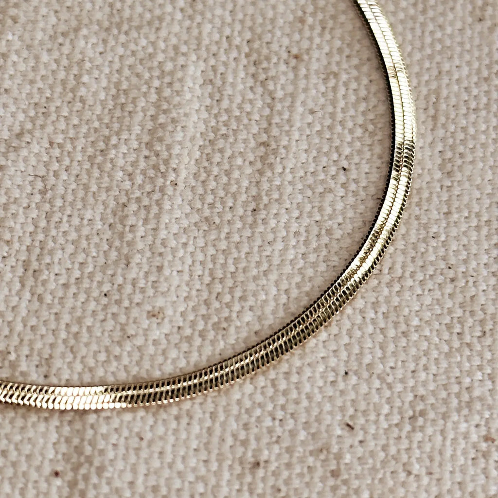 Gold necklace on a beige fabric background