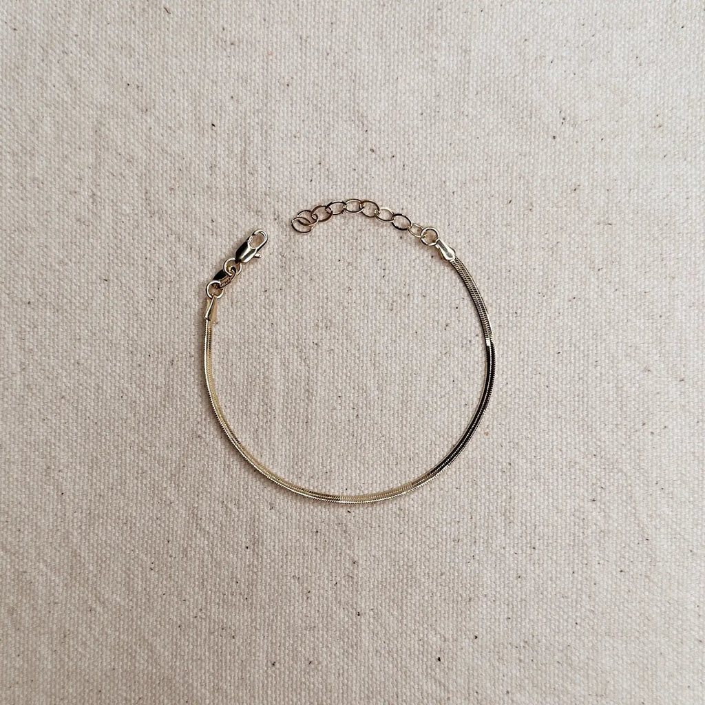 Gold bracelet on a textured beige background