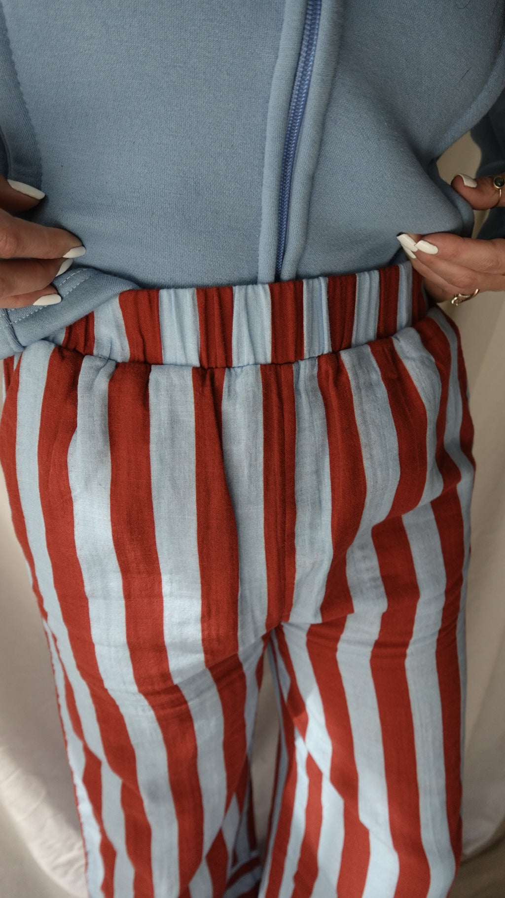 Close-up of a red and white striped fabric with a gray bag next to it.
