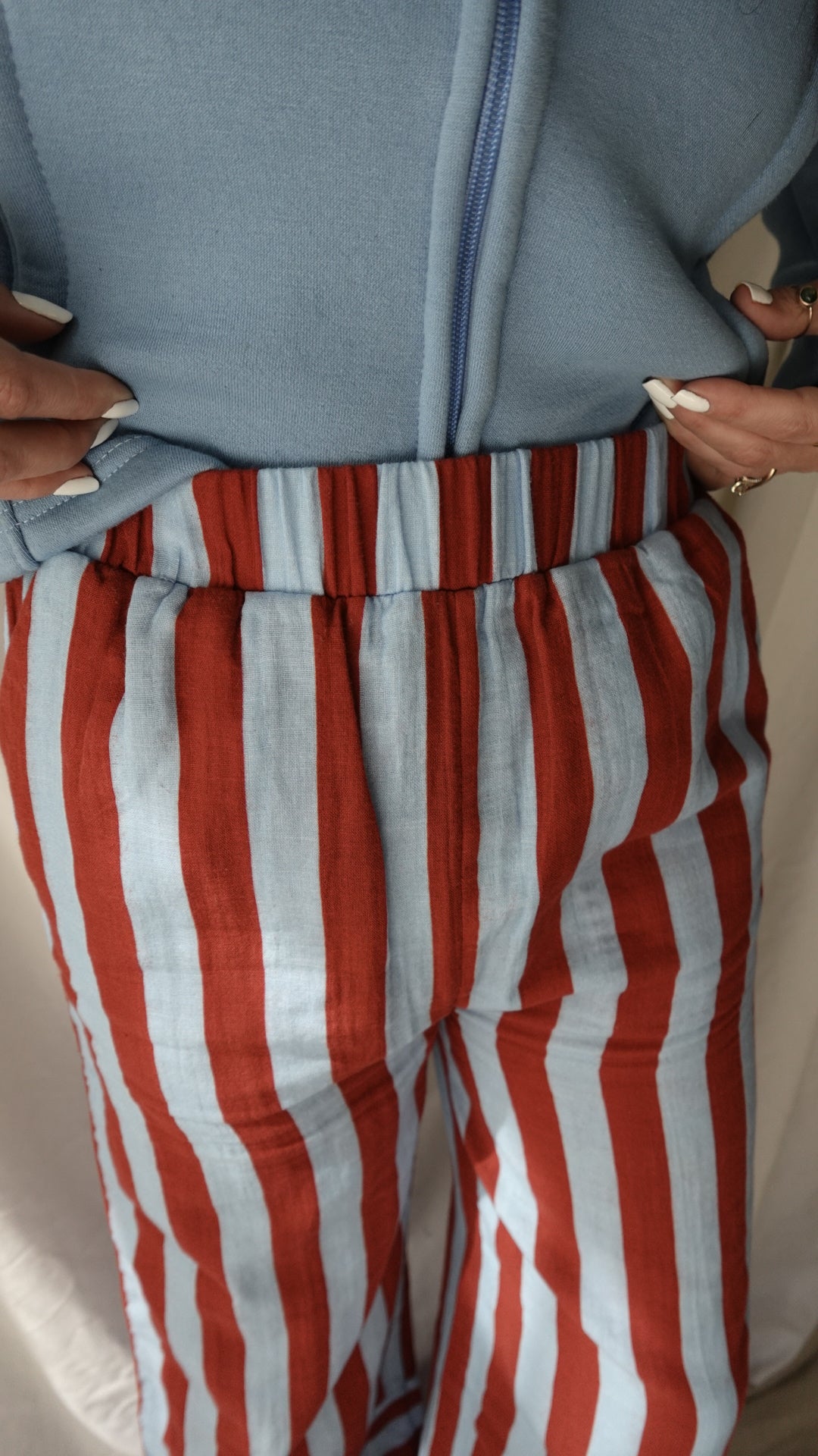 Close-up of a red and white striped fabric with a gray bag next to it.