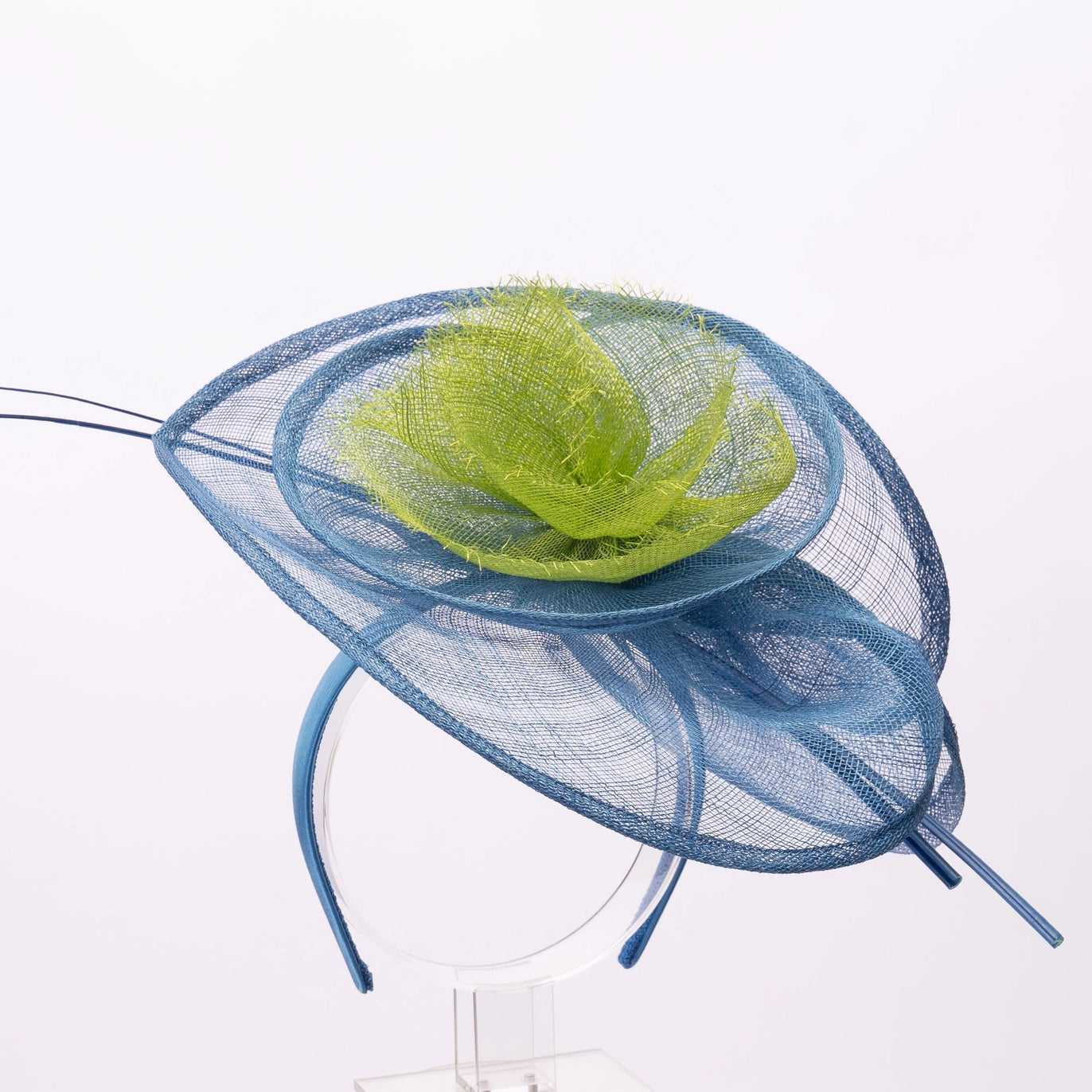 Blue decorative hat with a green feather on a white background