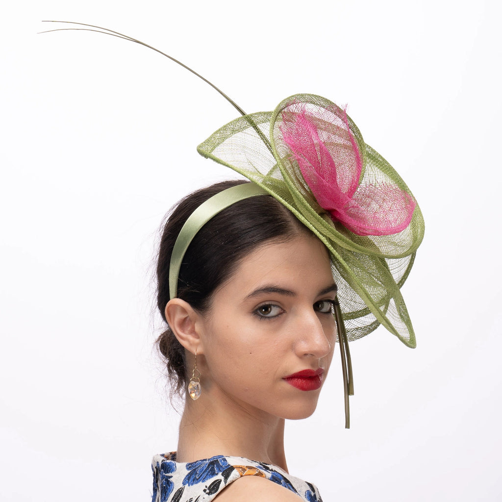 Woman wearing a decorative headband with pink and green floral elements on a white background