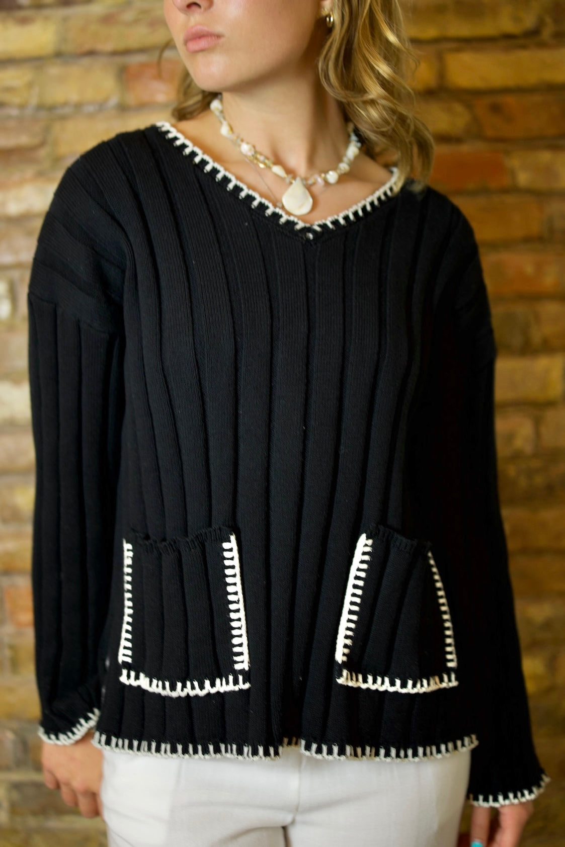 Cozy and stylish Nior White Stitching Wide Rib Sweater with front pockets, perfect for layering or pairing with summer shorts