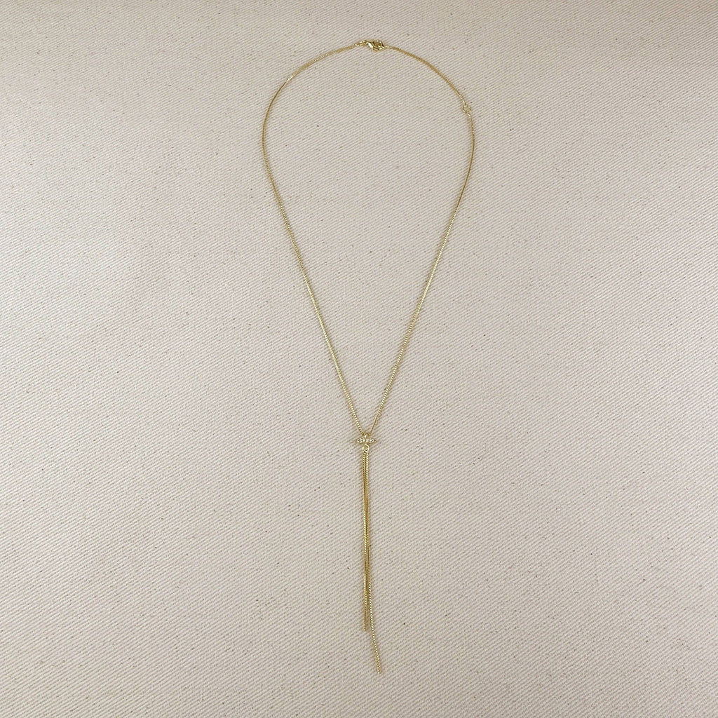 Gold necklace on a beige fabric background