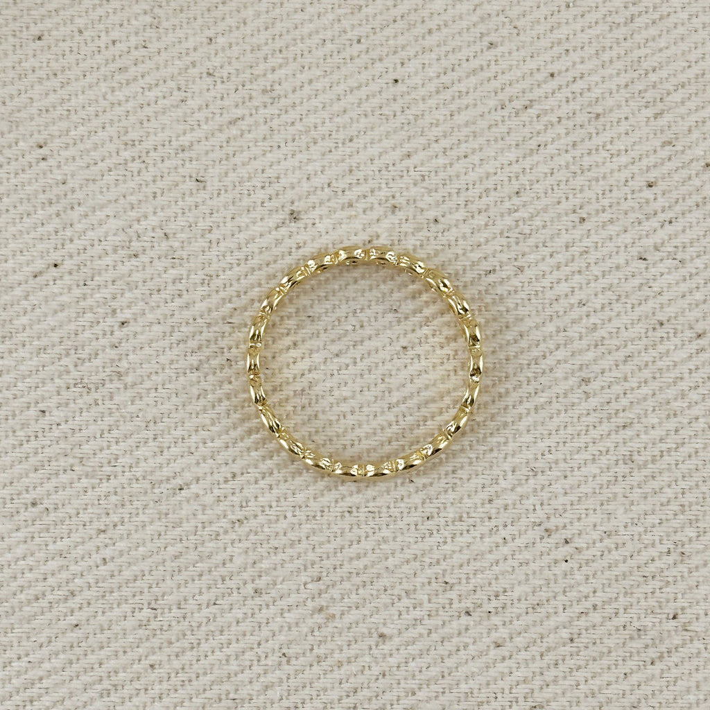 Gold ring on a textured beige background