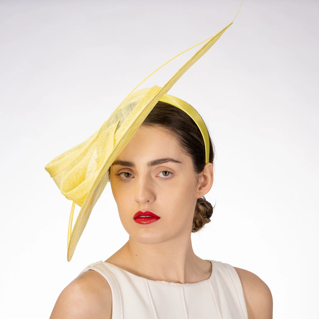 Woman wearing a yellow decorative headpiece against a white background