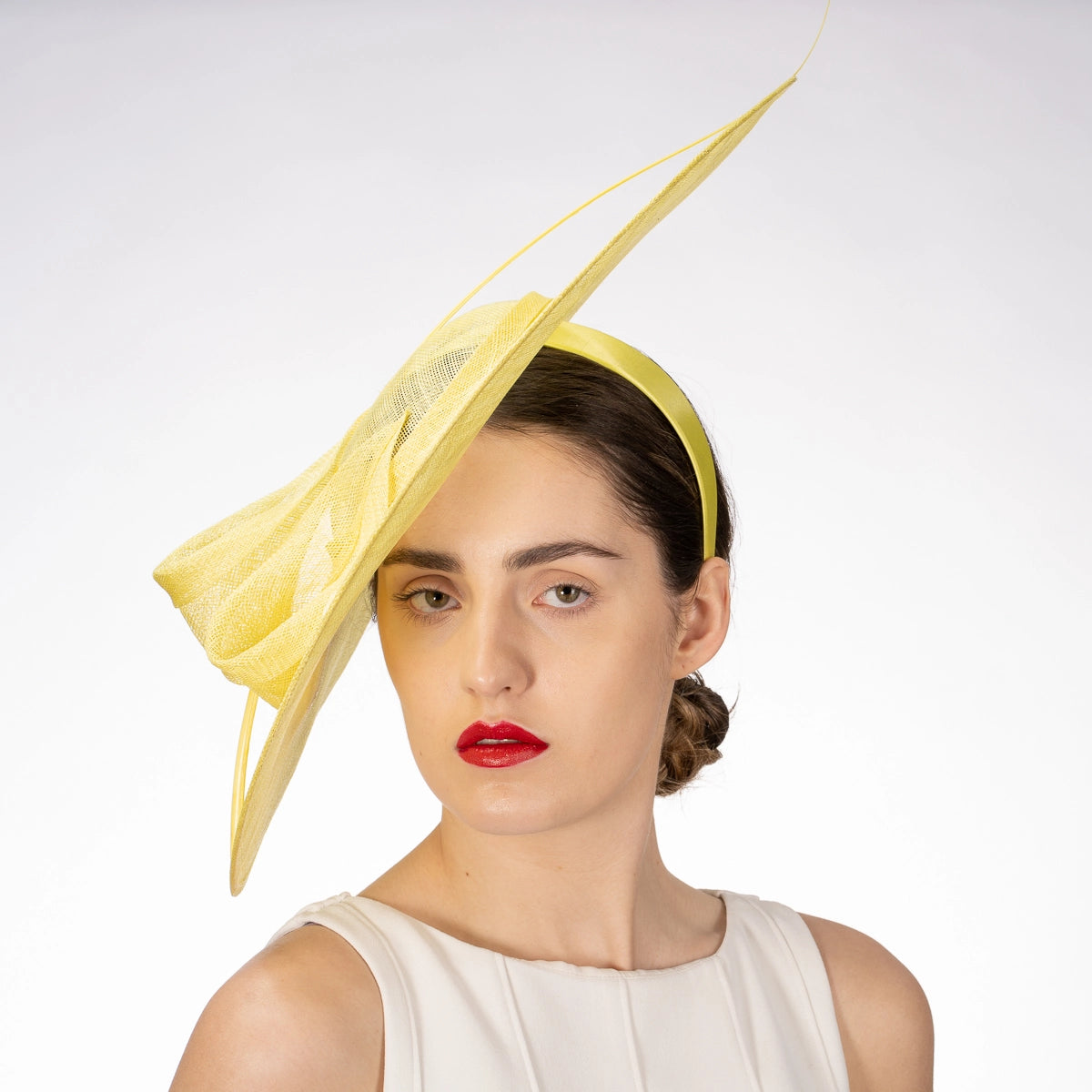Woman wearing a yellow decorative headpiece against a white background