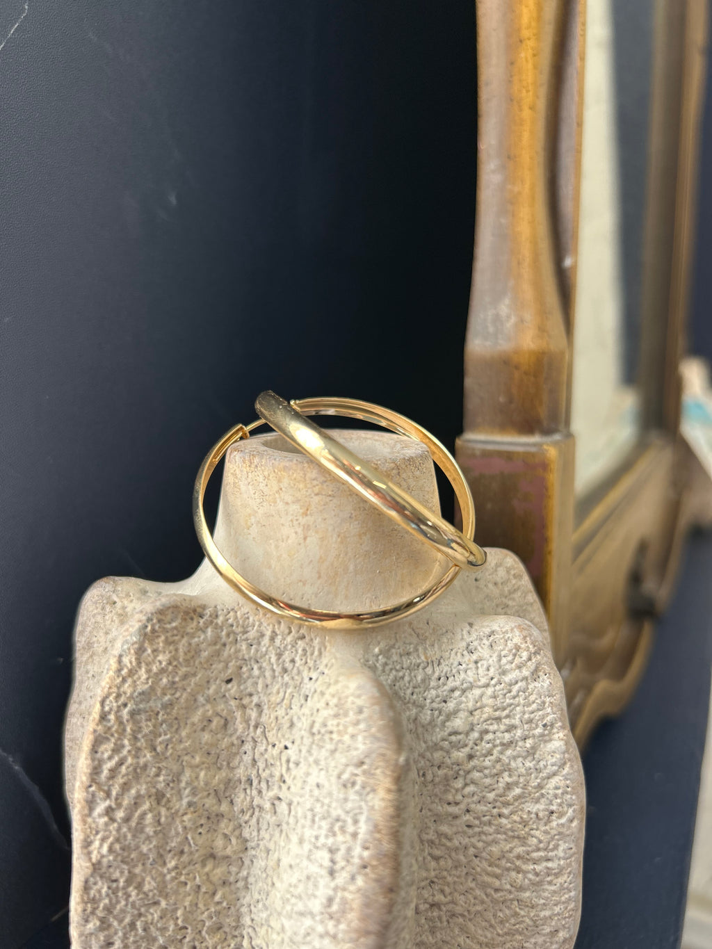 Gold ring on a stone surface with a dark background