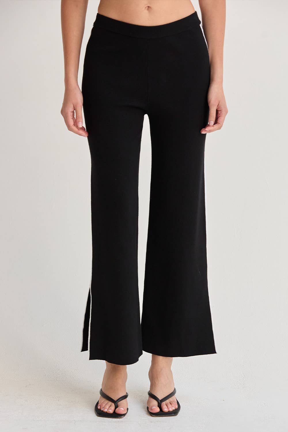 Black wide-leg pants worn by a person on a light gray background
