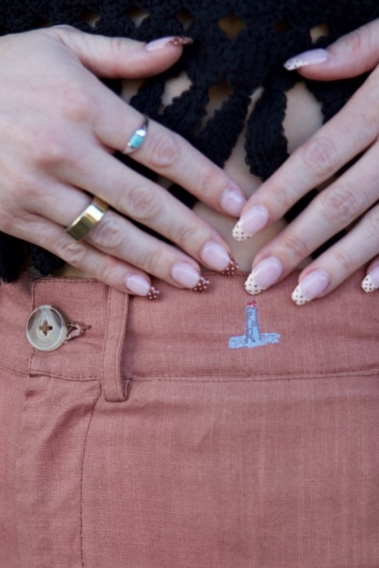 Close-up of hands with painted nails on a pink shirt with a number '1'.