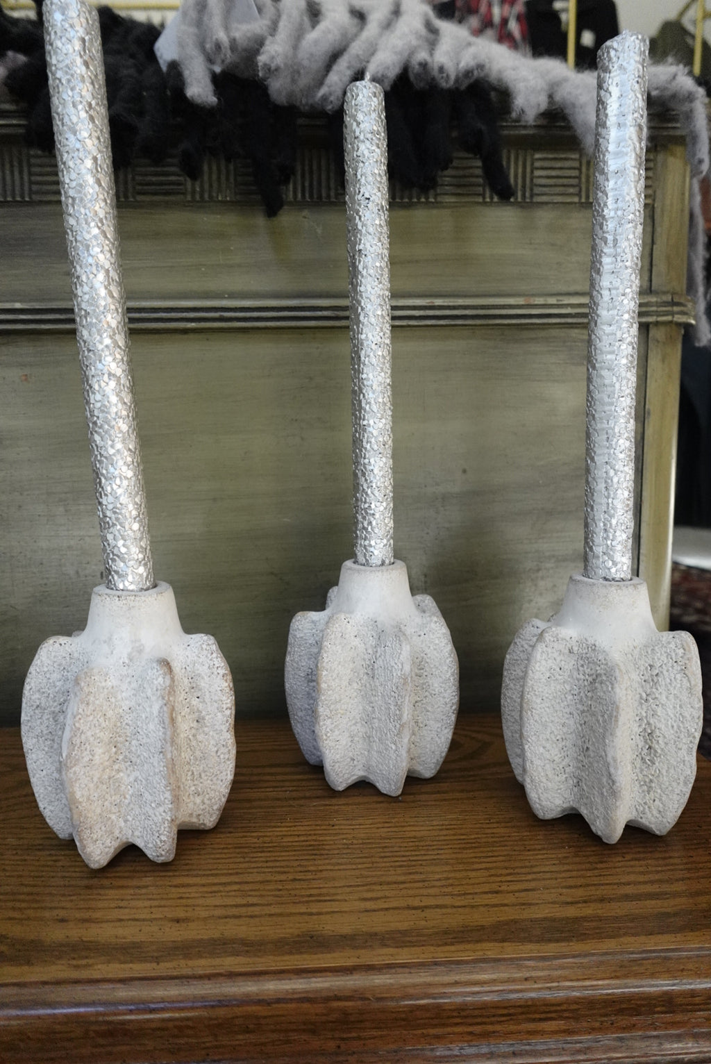 Decorative items with silver handles and beige bases on a wooden surface.