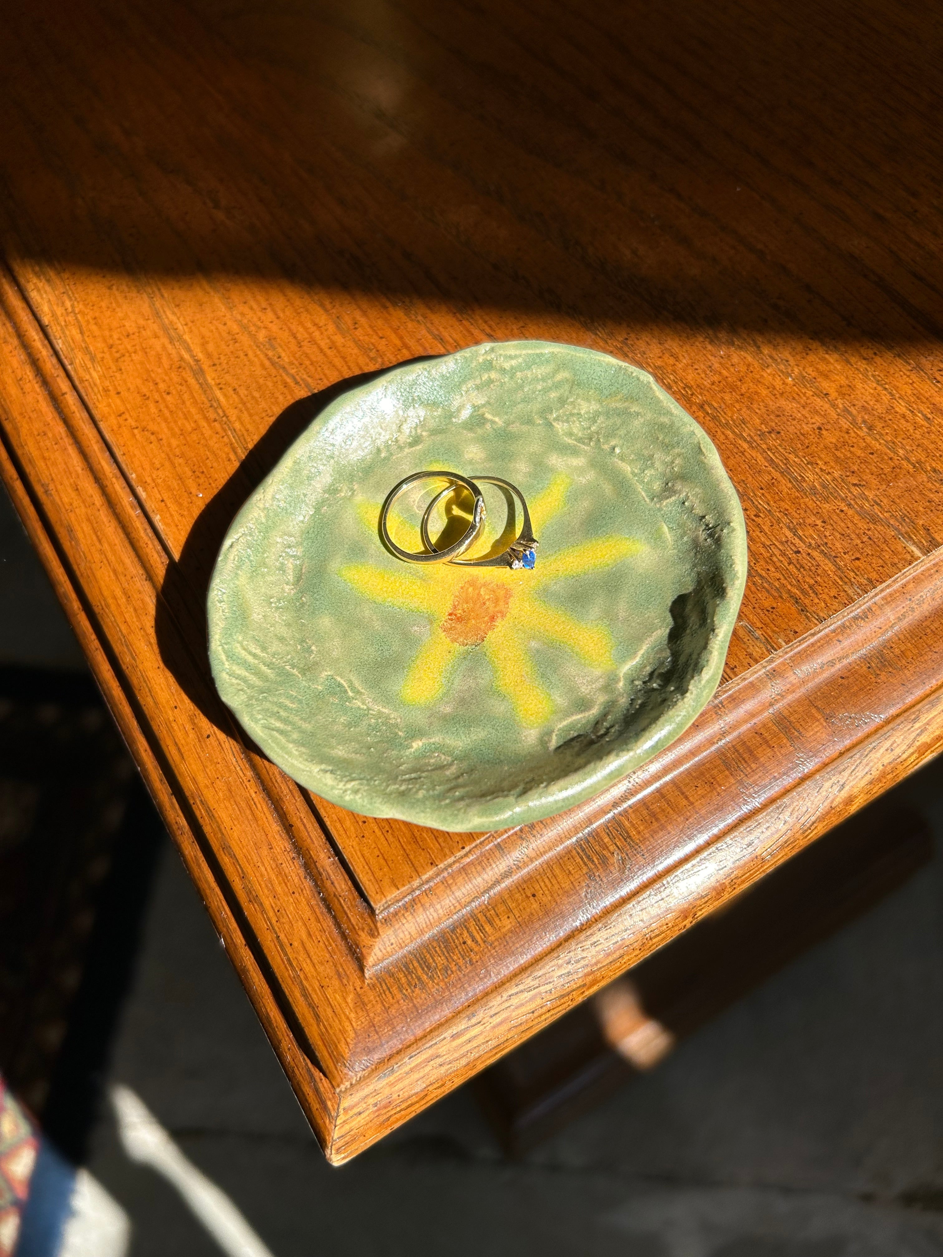 Green stone with a sun design on a wooden surface