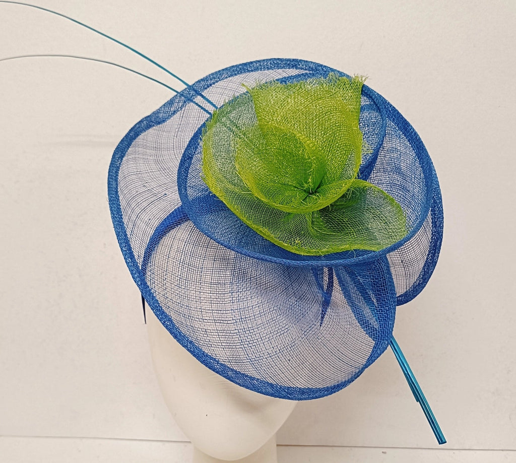 Blue and green decorative headpiece on a mannequin head with a plain background