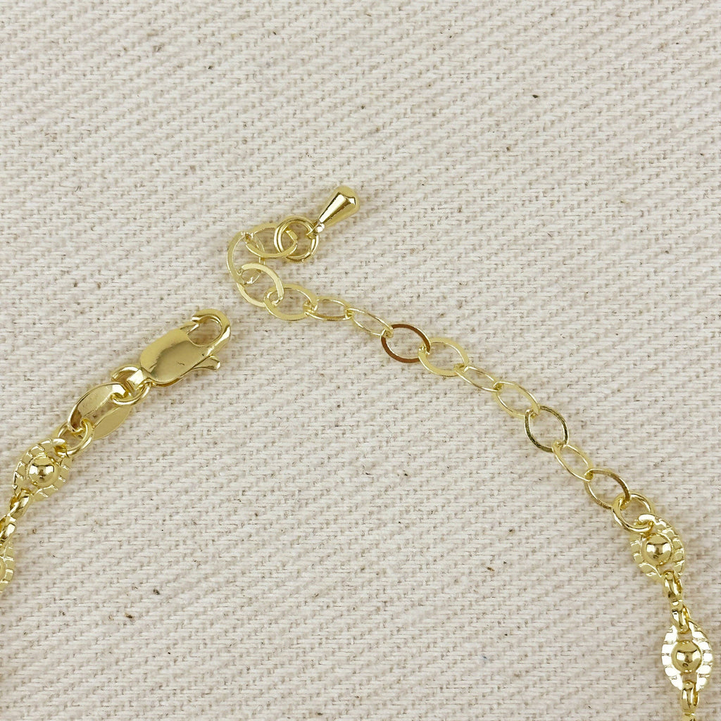 Gold bracelet with a clasp on a textured beige background