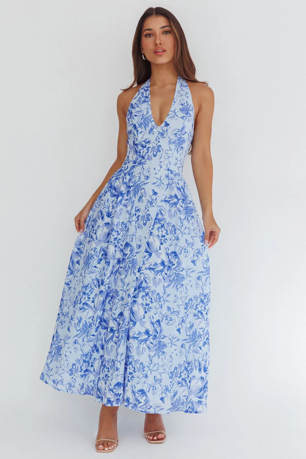 Woman wearing a blue floral dress against a white background