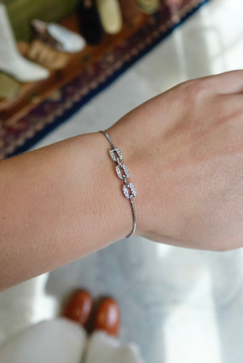 Silver bracelet on a wrist with a blurred background