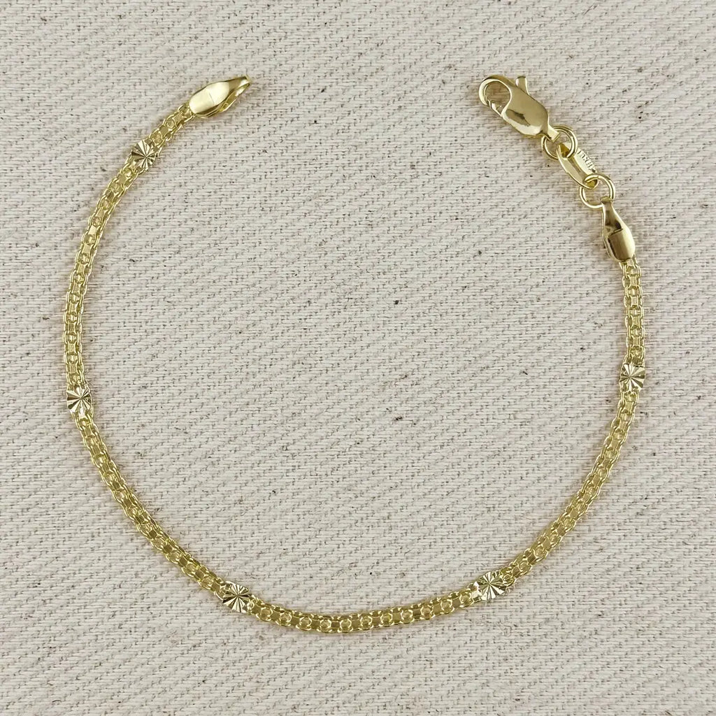Gold bracelet on a textured beige background