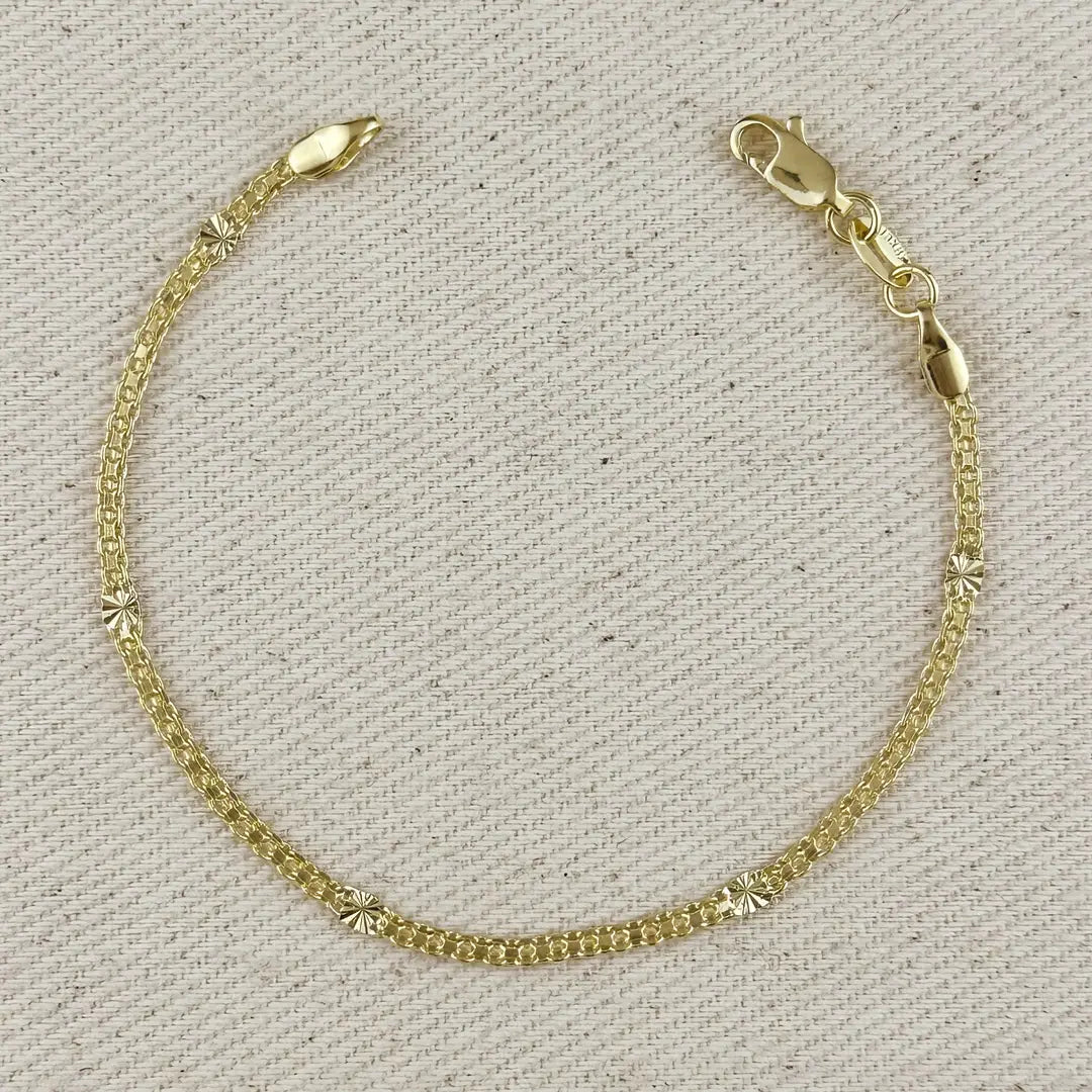 Gold bracelet on a textured beige background
