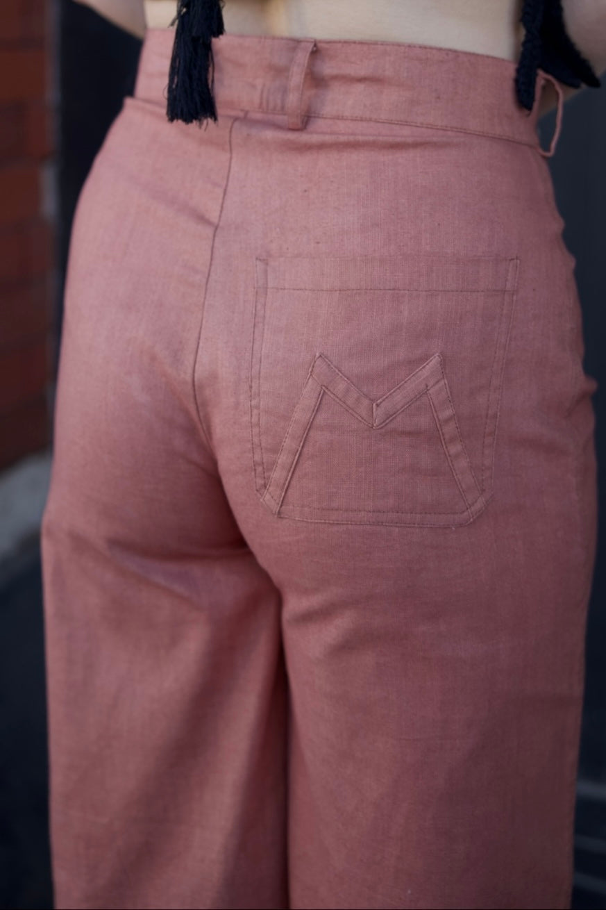 Pink pants with a back pocket detail on a blurred background