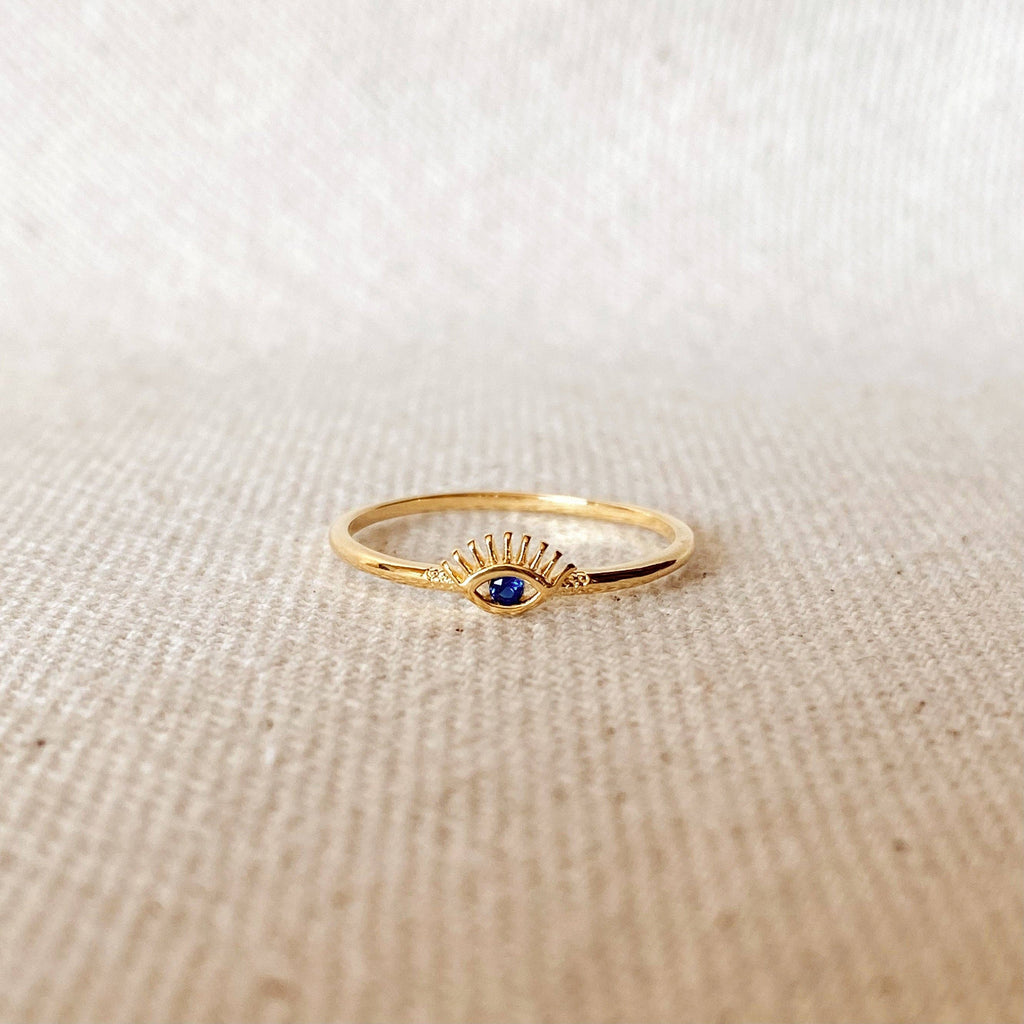 Gold ring with a blue gemstone on a beige fabric background