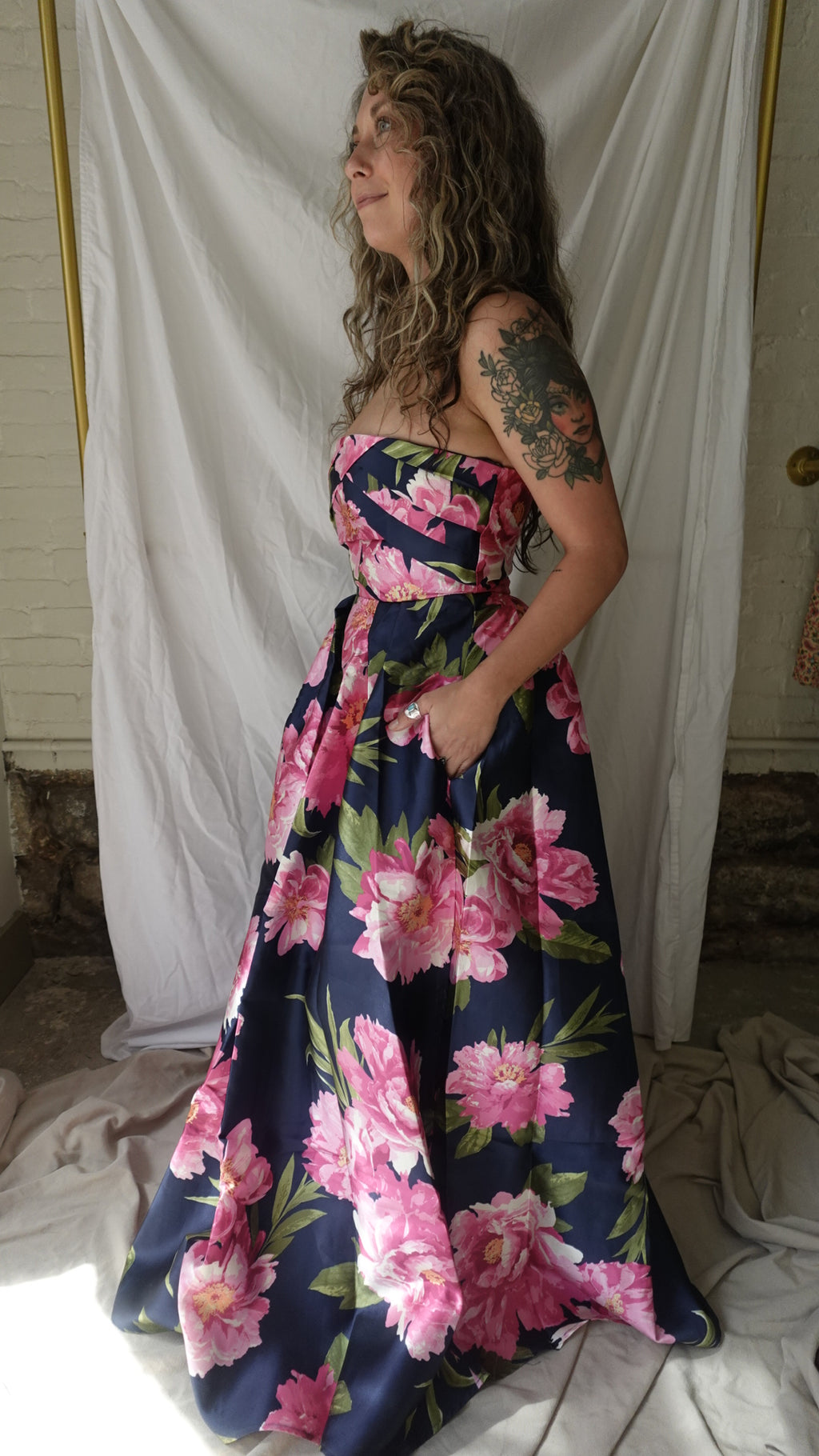 Person wearing a floral dress lying on a white sheet