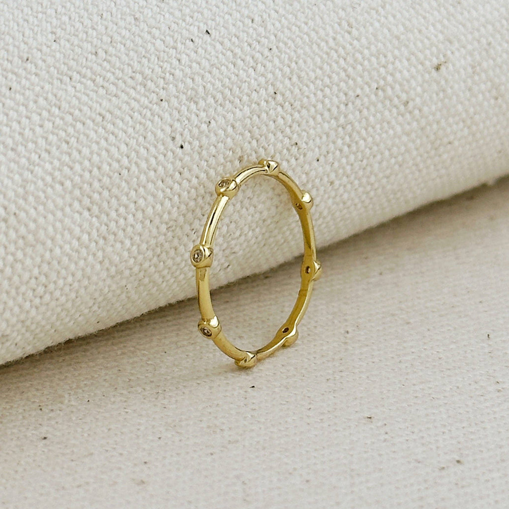 Gold ring with a unique design on a beige fabric background