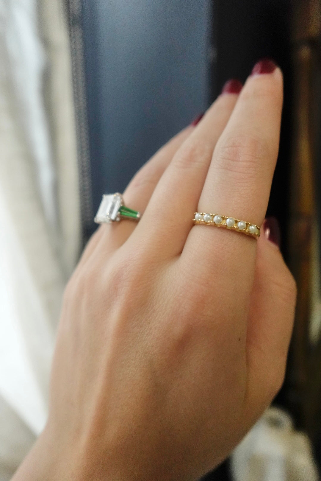 Hand wearing two rings with a blurred background