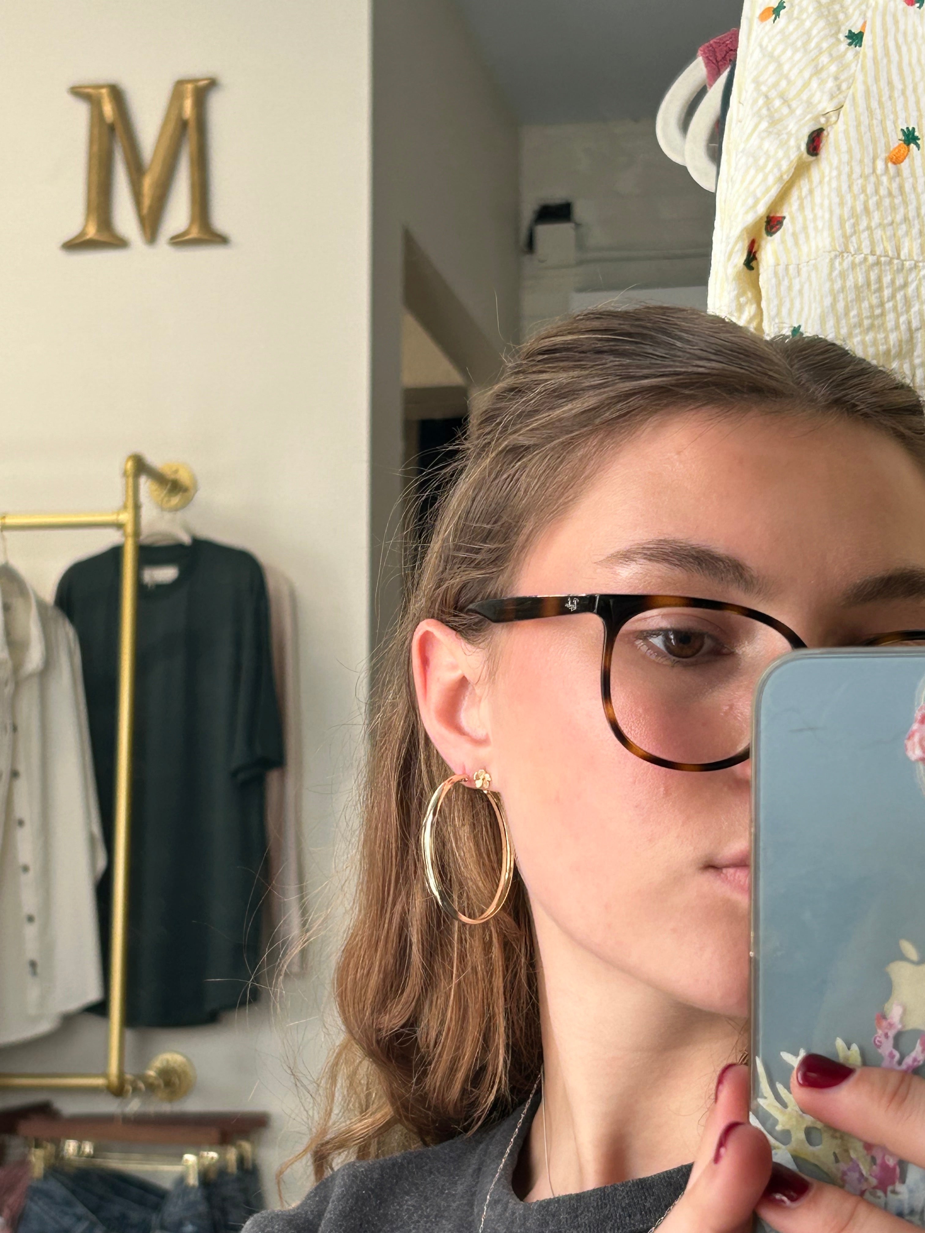 Person wearing glasses and a headband, taking a mirror selfie.