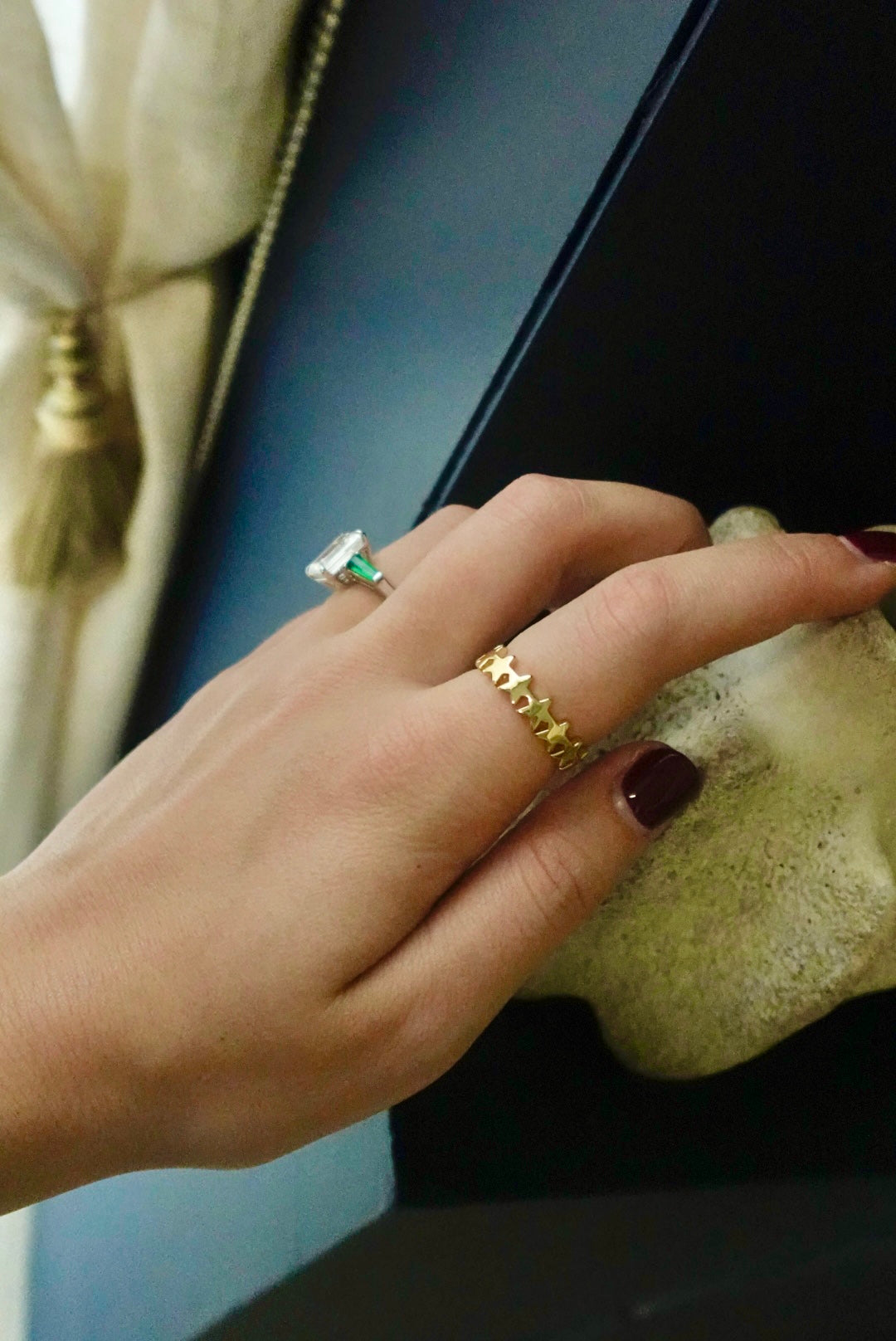 Close-up of a hand wearing two rings with a blurred background