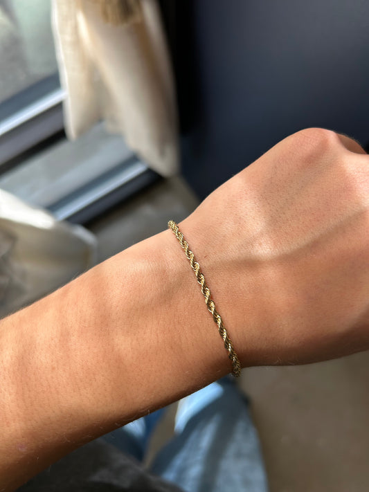 Gold bracelet on a wrist with a blurred background