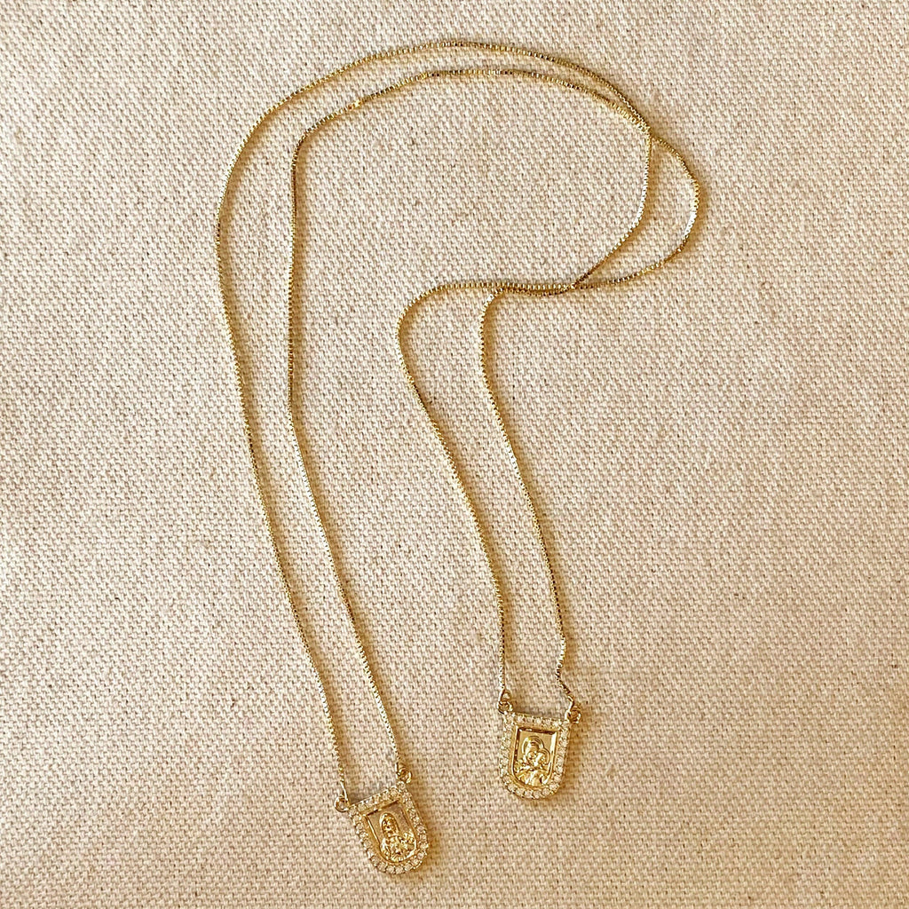 Gold necklace with a pendant on a beige fabric background