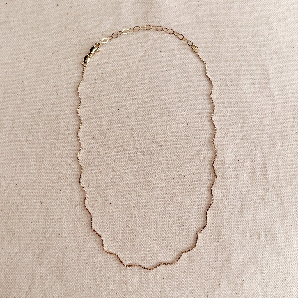 Gold necklace on a beige fabric background