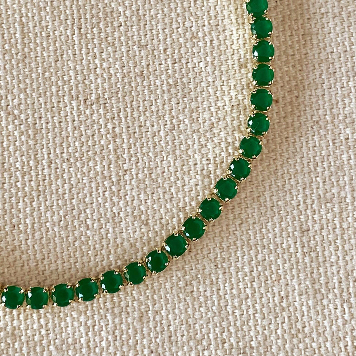 Green gemstone bracelet on a beige fabric background