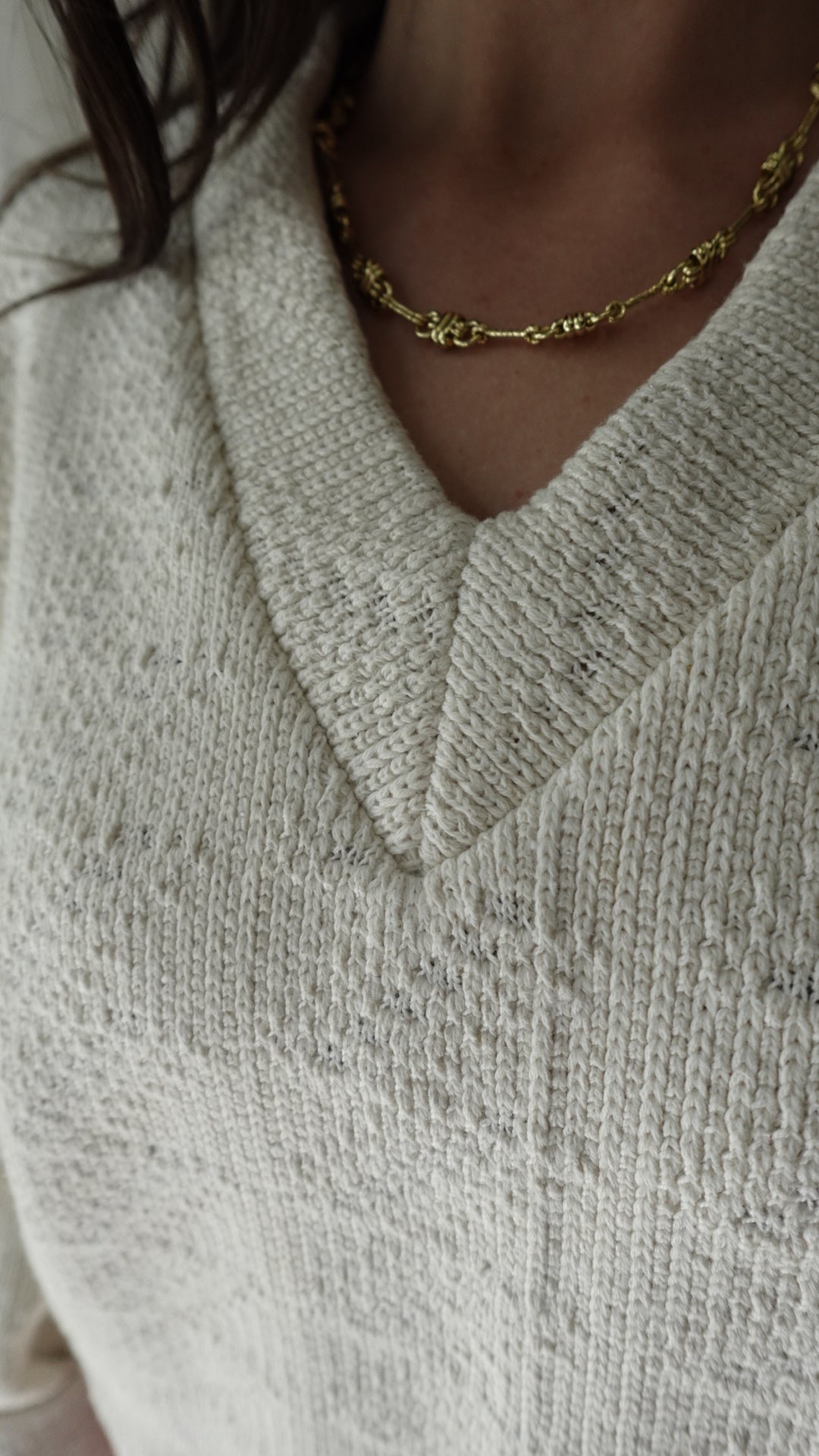 Close-up of a textured fabric surface with a gold chain.