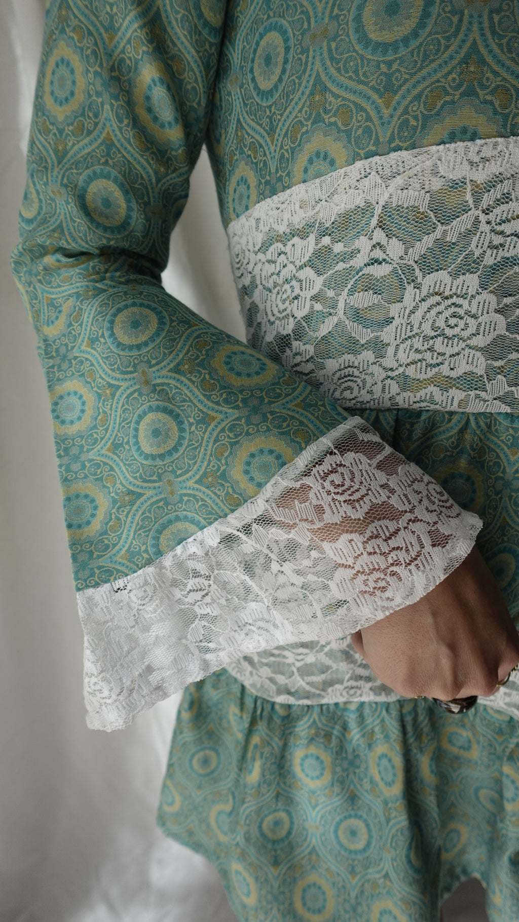 Close-up of a garment with lace detailing on a white background