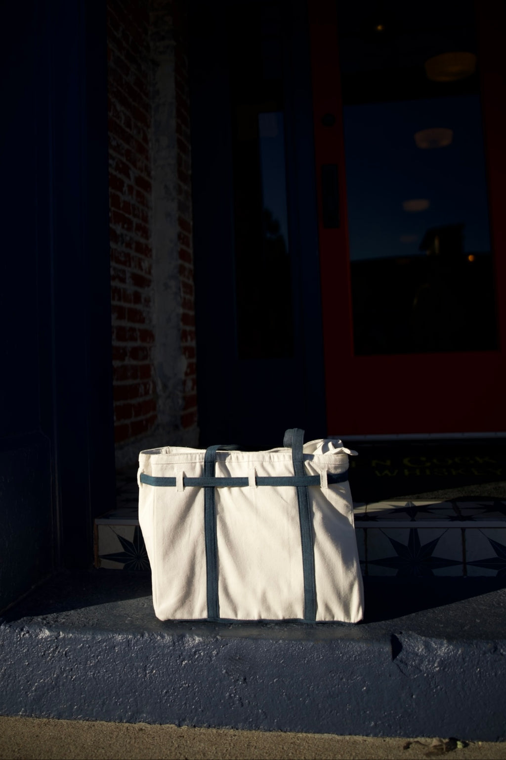 Beige tote bag on a dark surface with a blurred background