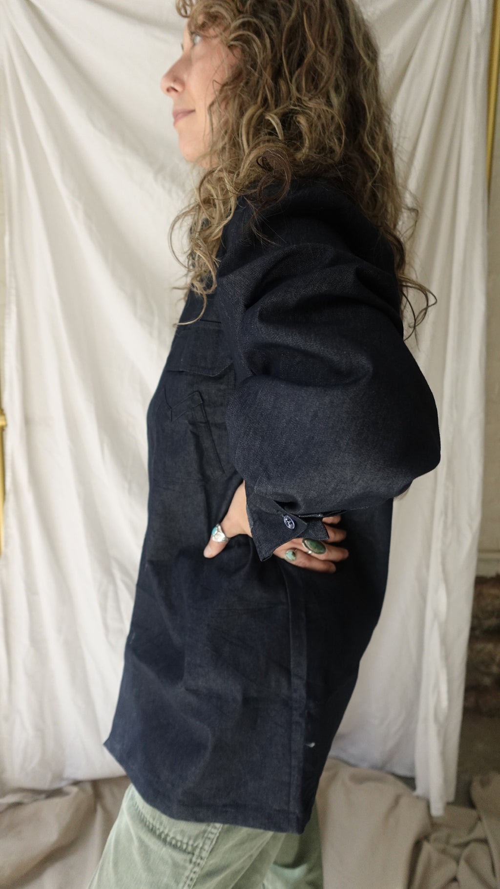 Person wearing a dark coat lying on a white surface