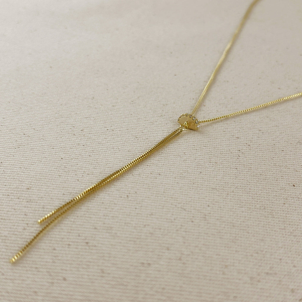 Gold necklace on a beige fabric background