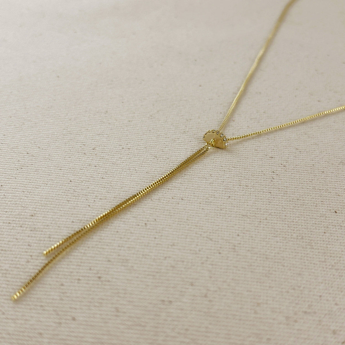 Gold necklace on a beige fabric background