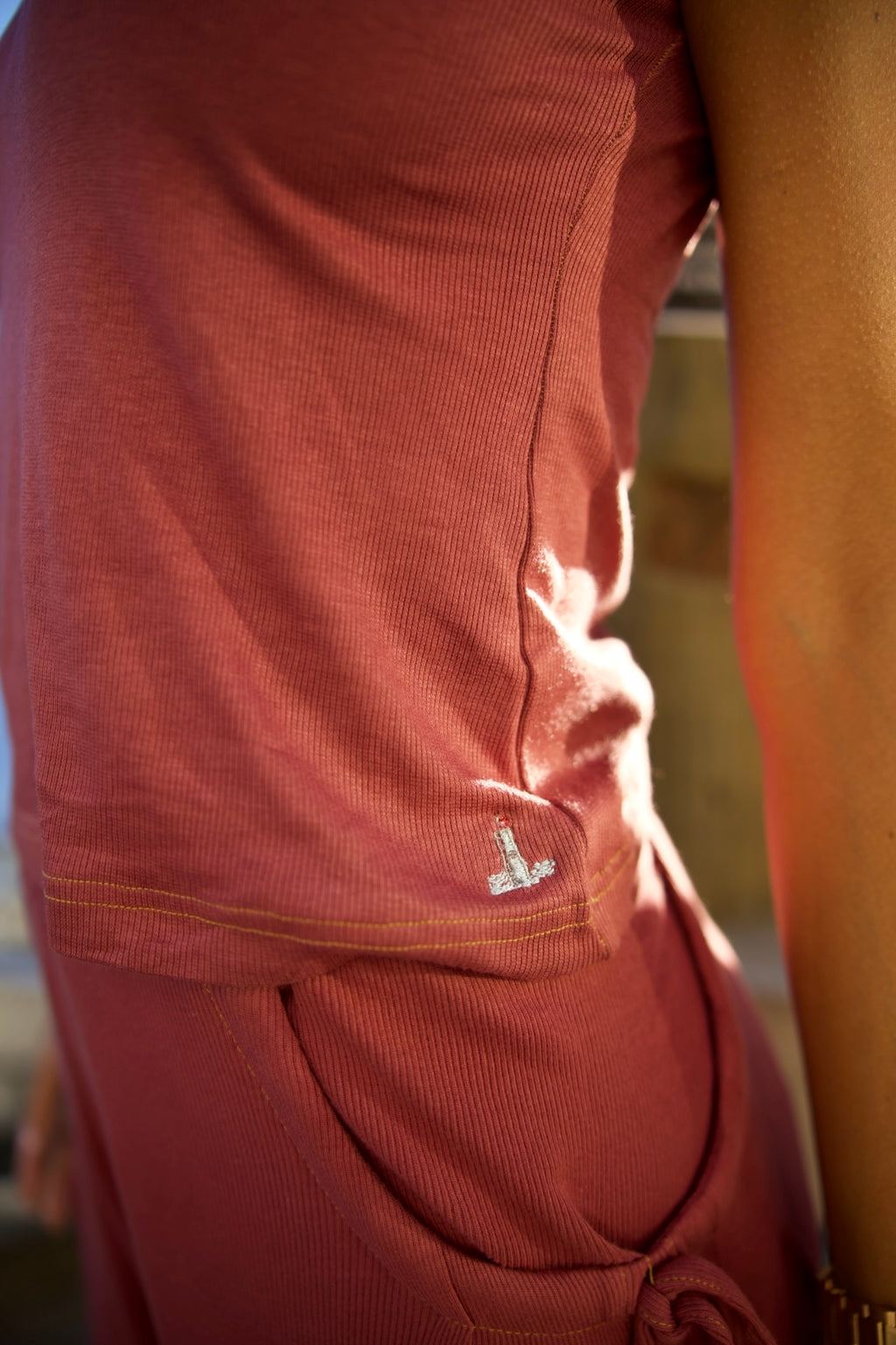 Close-up of a person wearing a red shirt with a logo on a blurred background