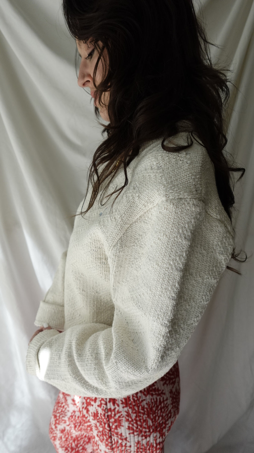 Person wearing a textured white garment on a white background