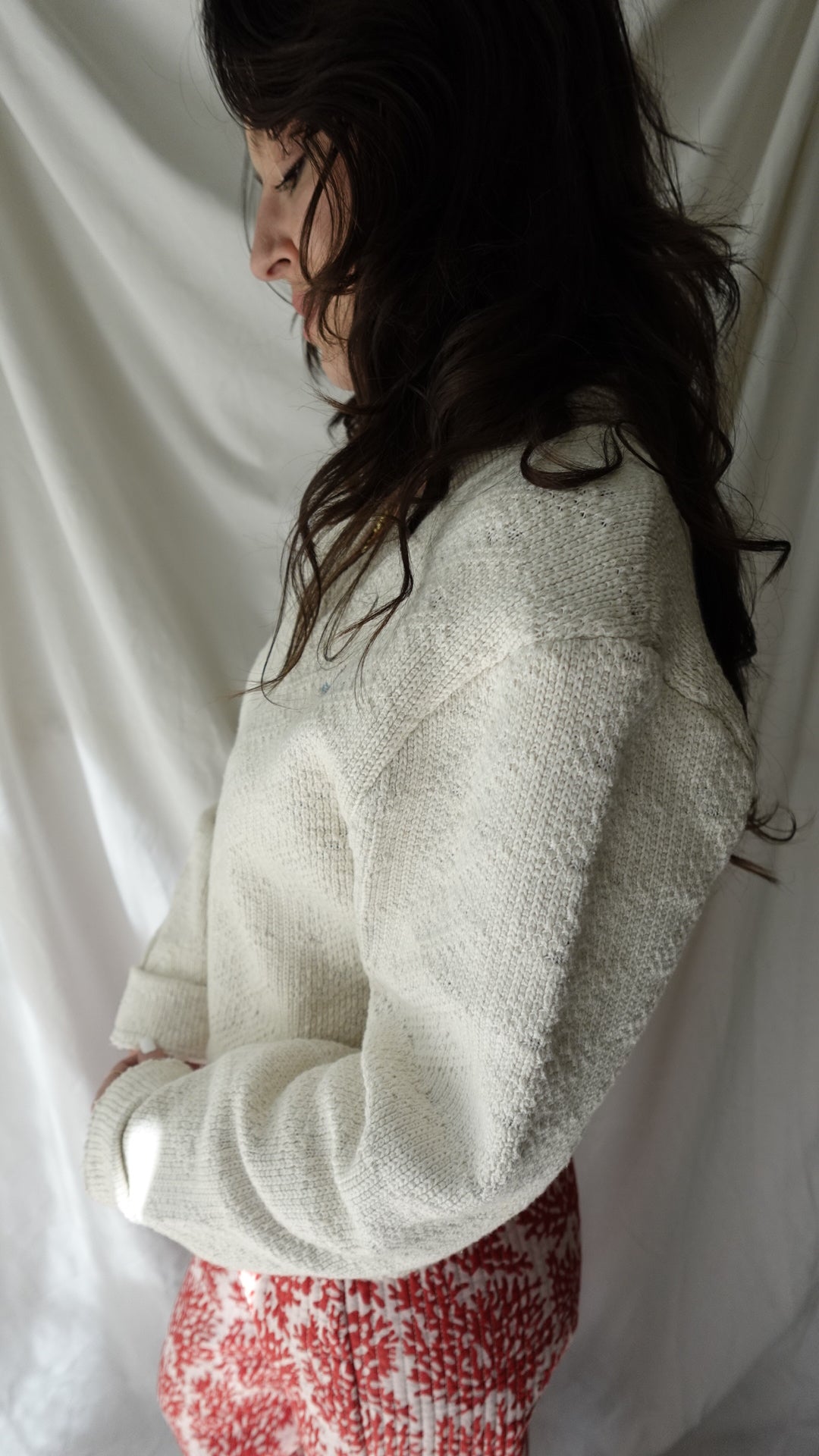 Person wearing a textured white garment on a white background