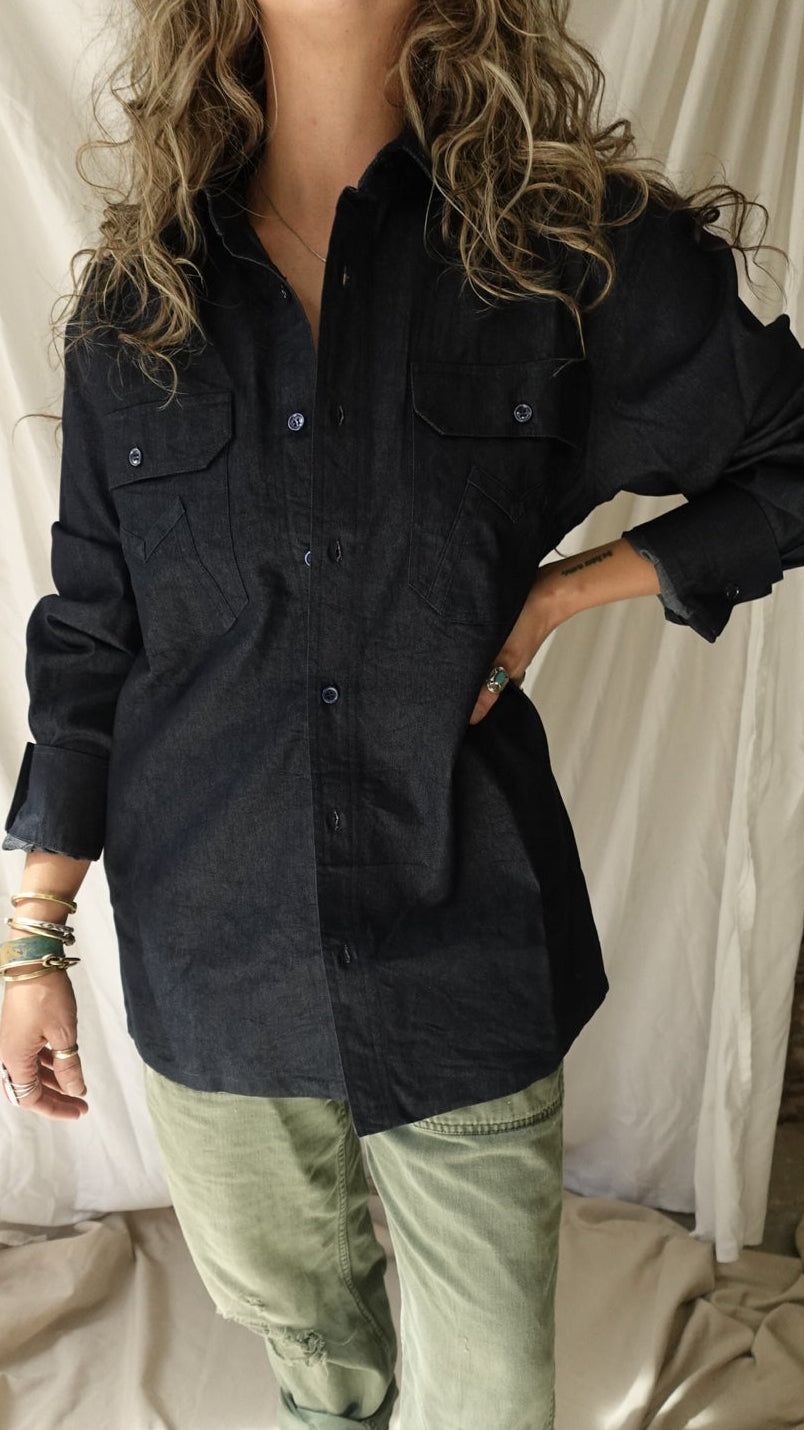 Person wearing a dark jacket and light pants standing on a white surface with a decorative background