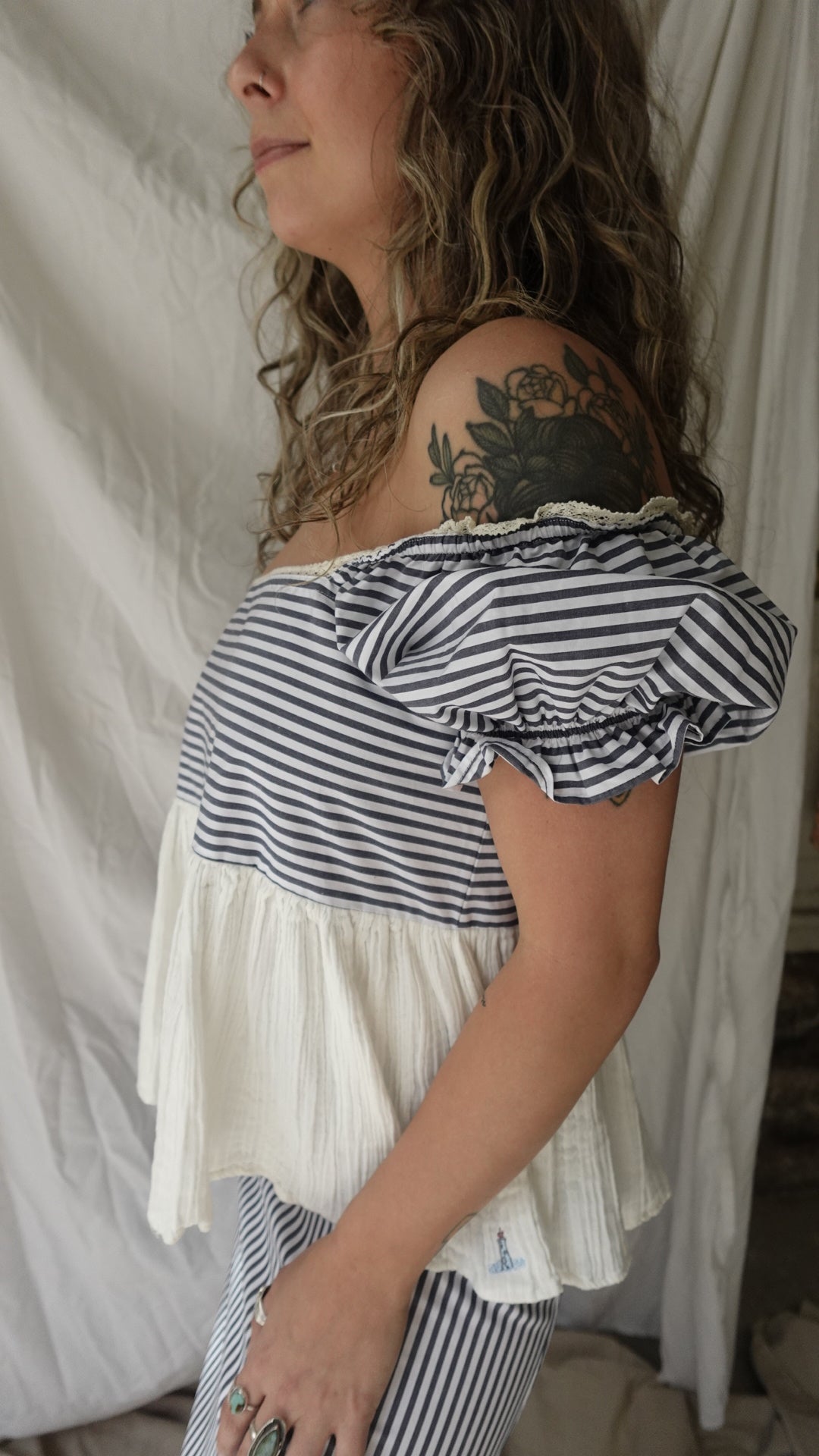 Woman wearing a black and white striped dress lying on a bed.