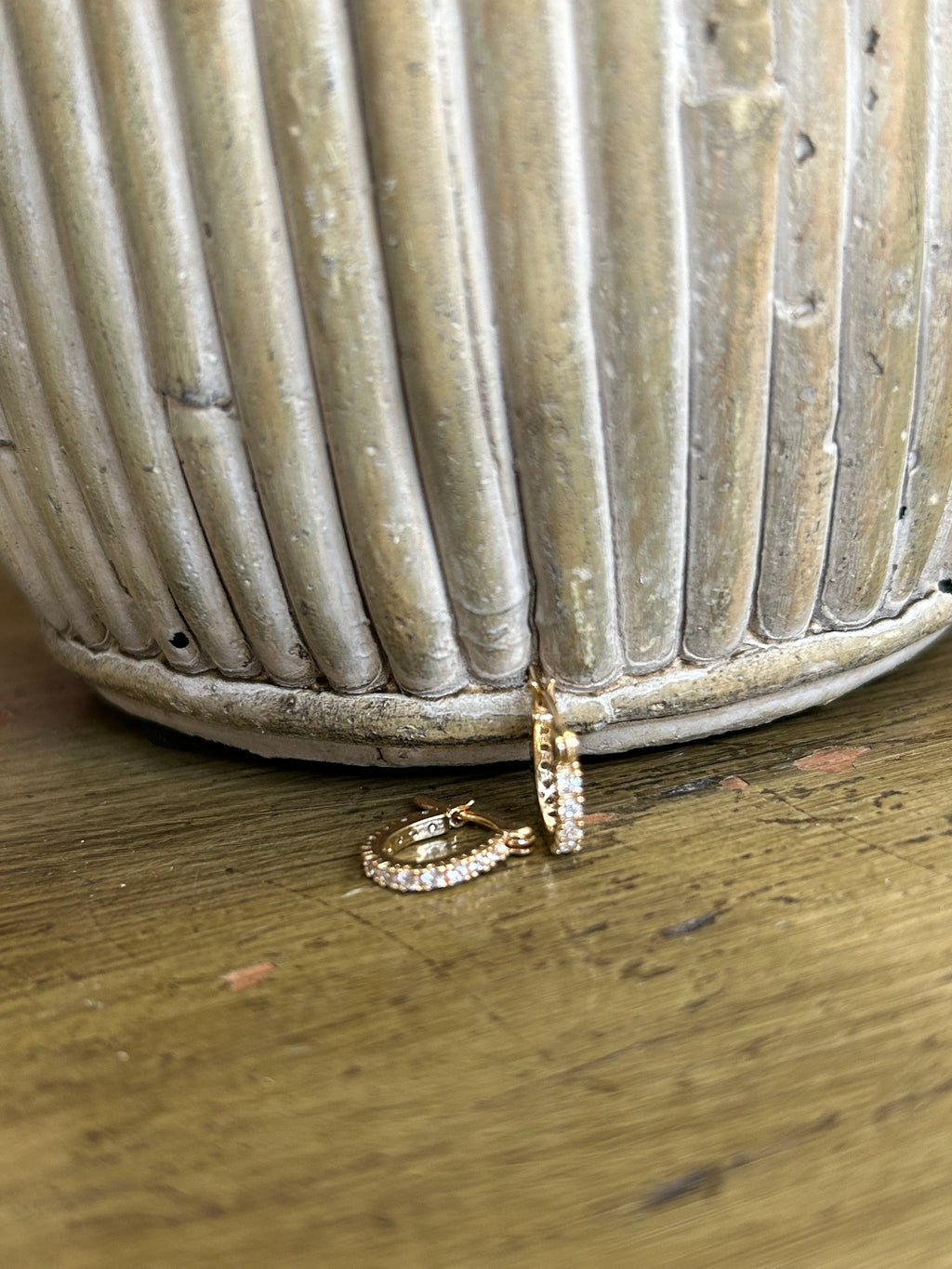 Gold ring and hoop earring on a textured surface