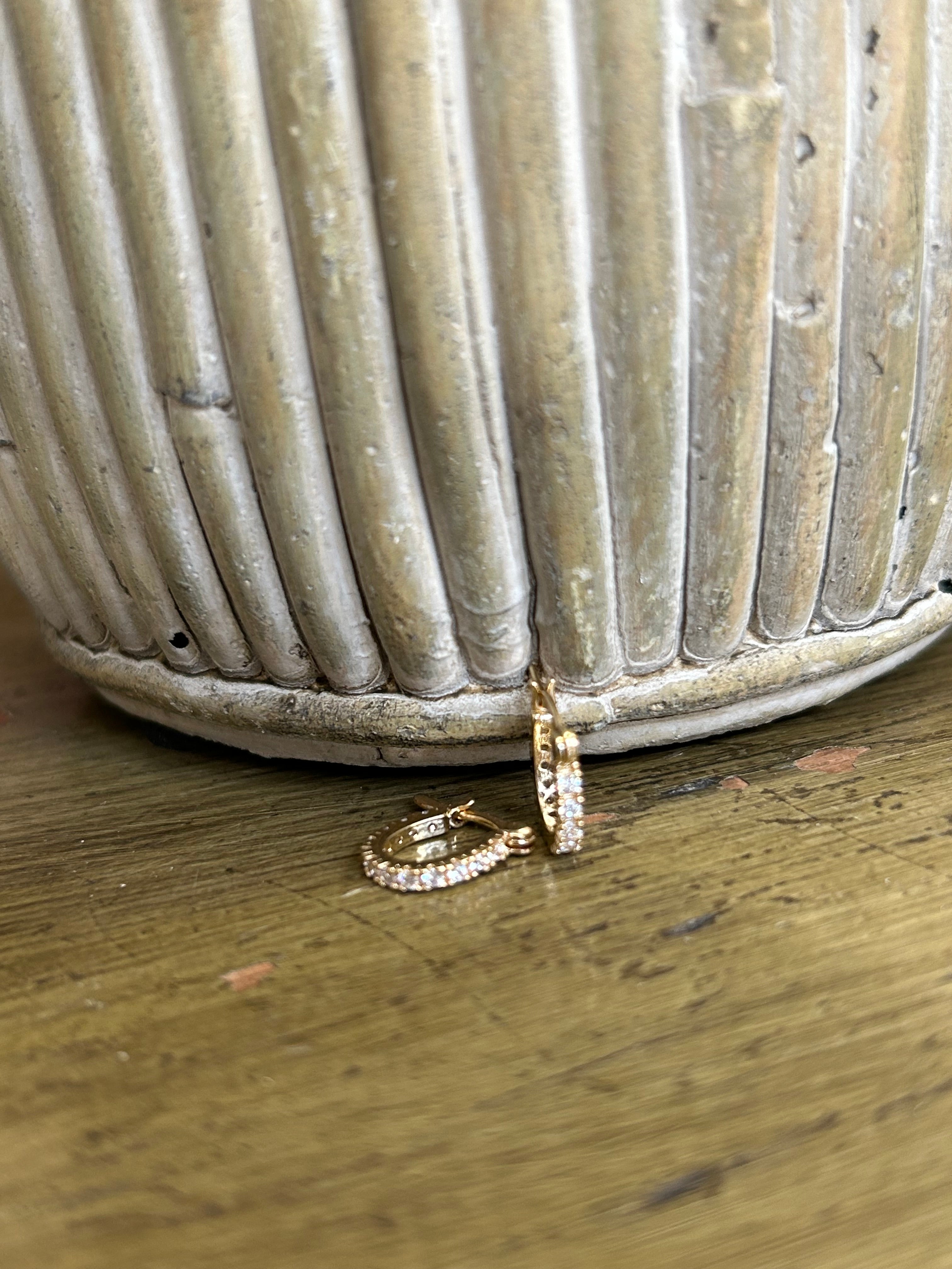 Gold ring and hoop earring on a textured surface